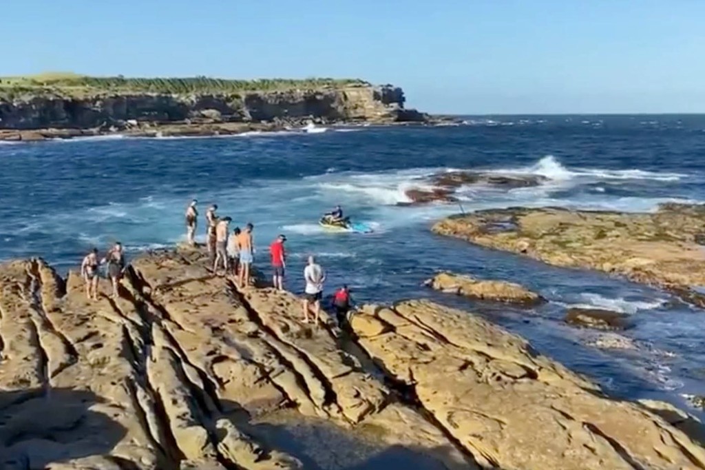 People near the ocean look at the swimmer who was eaten by a great white shark, as the authorities ordered people to stay away from the water.