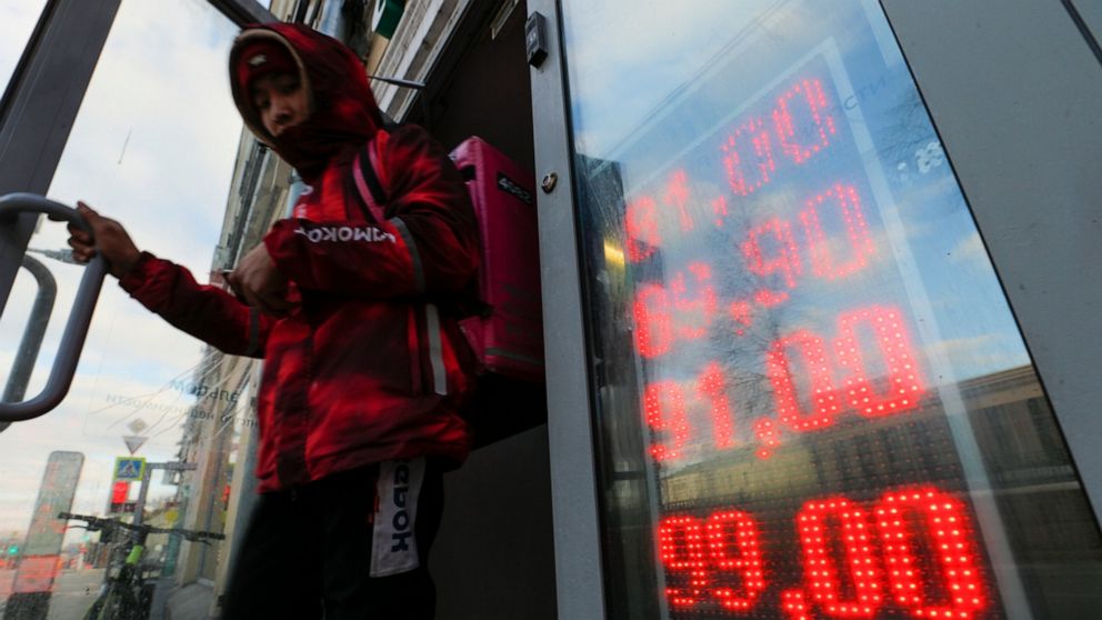 The ruble drops sharply with the bite of sanctions, sending Russians to the banks