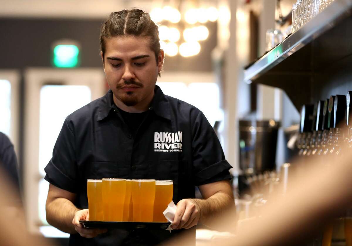 Alan Rodriguez holds a tray from Russia's River Brewing's Pliny the Younger at Russia's River Brewing Company on February 1, 2019 in Windsor, California.