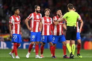 Referee Daniel Seibert interacts with Koke of Atletico Madrid and his teammates.