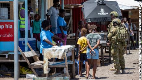 Australian Army soldiers talk with local residents during a community engagement patrol across Honiara on November 27, 2021.