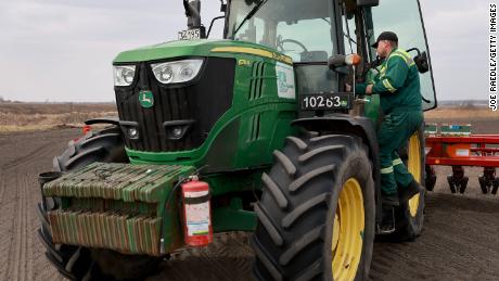 Ukrainian farmer Morda Vasyl enters the John Deere tractor cabin.